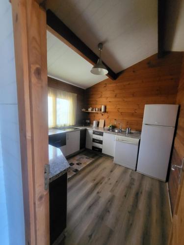 a kitchen with white appliances and wooden walls at Casa Madera Urbanizacion Socorro in Seville