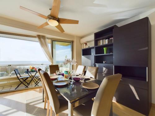 une salle à manger avec une table et des chaises et un ventilateur de plafond dans l'établissement Appartement avec balcon vue mer pour 6 personnes !, à Les Sables-dʼOlonne