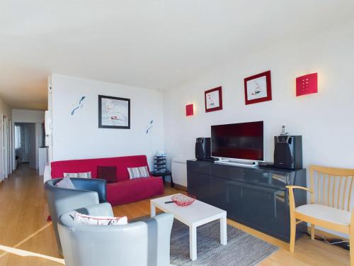 un salon avec un canapé rouge et une télévision dans l'établissement Appartement avec balcon vue mer pour 6 personnes !, à Les Sables-dʼOlonne