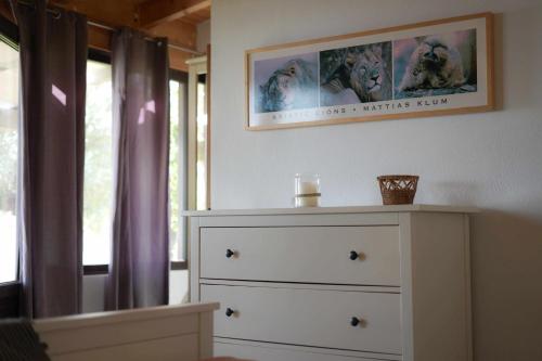 a bedroom with a dresser and a picture on the wall at Torre de Arriba Casa Rural in Benimantell