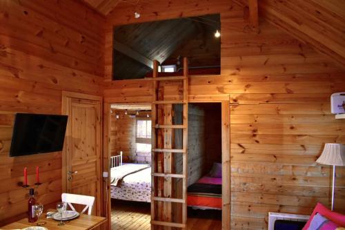 a log cabin with a bunk bed and a tv at Torre de Arriba Casa Rural in Benimantell