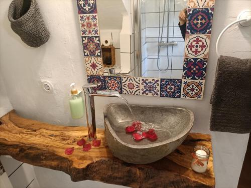 a bathroom with a stone sink and a mirror at Torre de Arriba Casa Rural in Benimantell