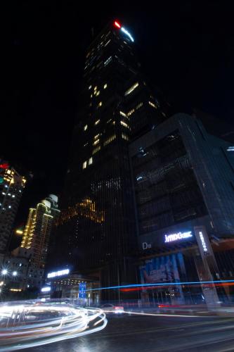 a tall building at night with streaks of lights at Rigel Hotel-Chongqing Jiefangbei Chaotianmen in Chongqing