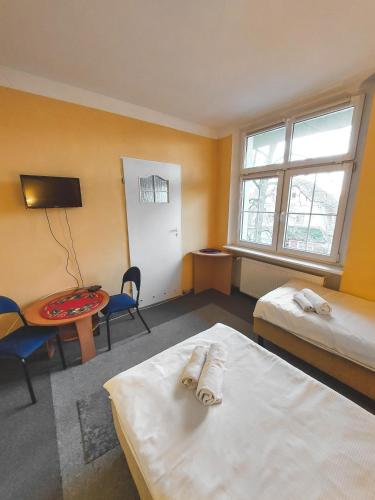 a room with a bed and a desk and a table at Pod starymi lipami in Szczecin