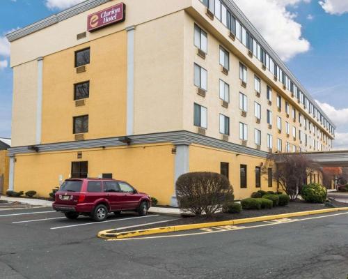 a red car parked in a parking lot in front of a hotel at Clarion Hotel Somerset - New Brunswick in Somerset