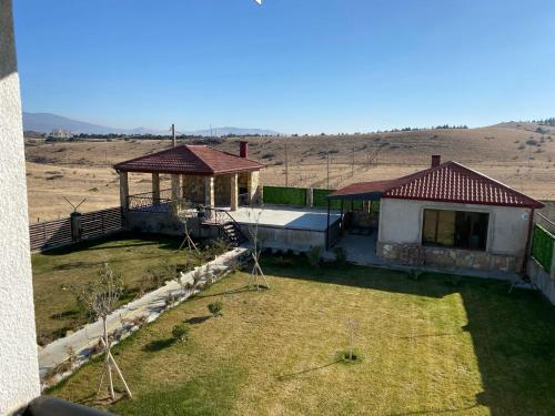 a house with a gazebo in the middle of a field at Camp Hotel Pura Vida in Tbilisi City