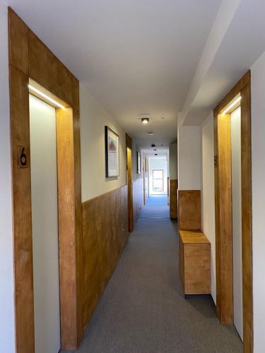 a hallway of a building with wooden doors and stairs at Camp Hotel Pura Vida in Tbilisi City
