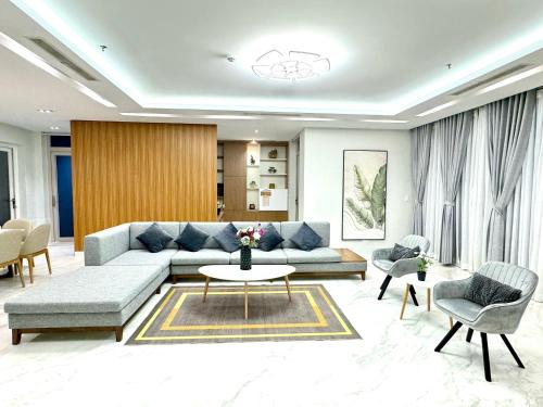 a living room with a couch and a table and chairs at Oceanami 5 Bedrooms Private Pool in Long Hai