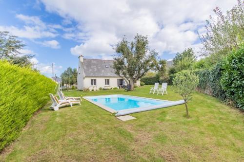 une cour arrière avec une piscine et une maison dans l'établissement Tasmannia - 3 étoiles avec piscine chauffée - Erquy, à Erquy
