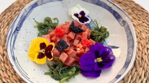a plate of food with fruit and flowers on it at Bahía - 30º hotels in Puerto de Mazarrón