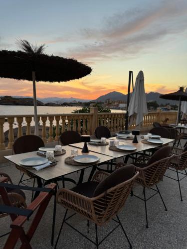 a group of tables with chairs and an umbrella at Bahía - 30º hotels in Puerto de Mazarrón