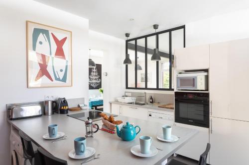 - une cuisine avec un comptoir avec des tasses bleues dans l'établissement La Lancieutine - A 300 mètres de la plage, à Lancieux