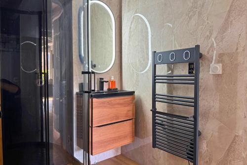 a bathroom with a shower and a sink and a mirror at Le Cottage Détente in Biscarrosse