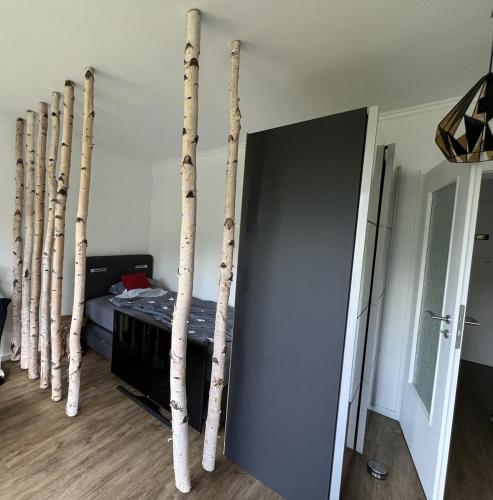 a room with a row of bamboo poles next to a bed at Fantastische Hotel Alternative in Oststeinbek