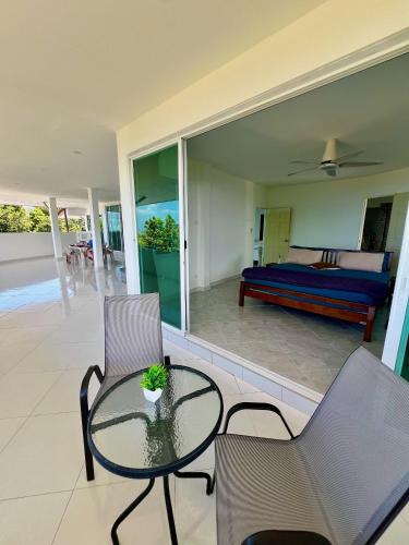 a room with a bed and a glass table and chairs at Long Beach Oceanview IL Villas Koh Lanta in Ko Lanta