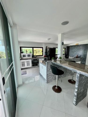 a kitchen with a bar with a chair in it at Long Beach Oceanview IL Villas Koh Lanta in Ko Lanta