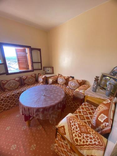 a room with couches and a table and a window at Adoir N'salh in Tiznit