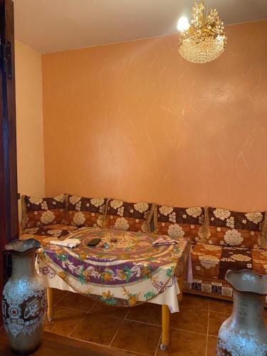 a room with a couch and a table and two vases at Adoir N'salh in Tiznit