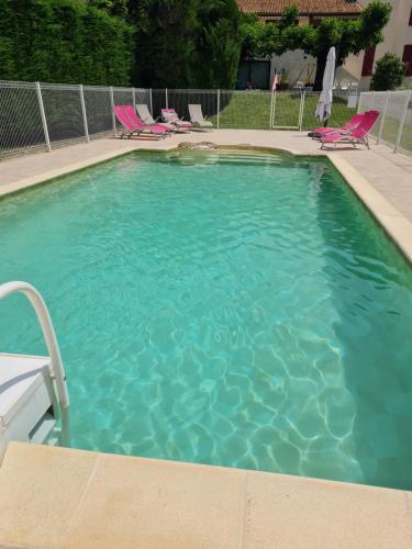 une grande piscine avec des chaises dans une cour dans l'établissement Le Gîte de la Bourges, à Saint-Pierre-de-Colombier
