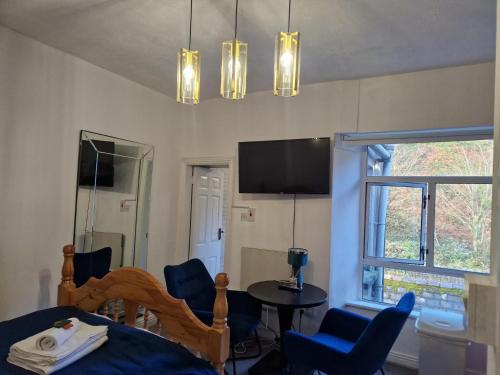 a bedroom with a bed and chairs and a tv at Cosy Cork Studio - cosyincork in Cork