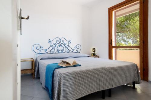 a bedroom with a bed with a book on it at Vista Golfo 2 in Isola di Porticciuolo