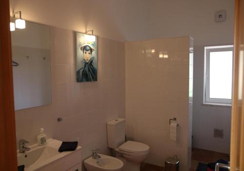 a bathroom with a white toilet and a sink at Monte Novo da Sobreira, rust en ruimte in zuid Alentejo in Ourique