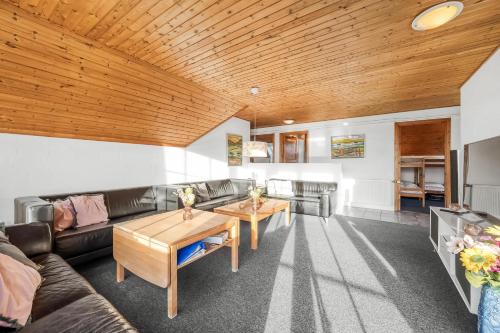 a living room with a couch and a table at Family-Friendly Holiday Home With Pool, Located Close To The North Sea In Vrist in Harboør