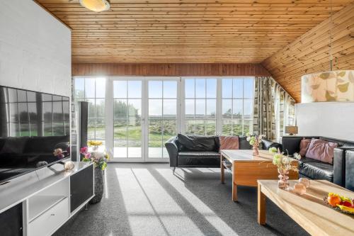 a living room with a couch and a table at Family-Friendly Holiday Home With Pool, Located Close To The North Sea In Vrist in Harboør
