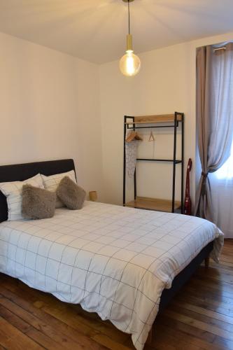 une chambre avec un lit avec une couette blanche dans l'établissement The Versailles Charm, à Versailles