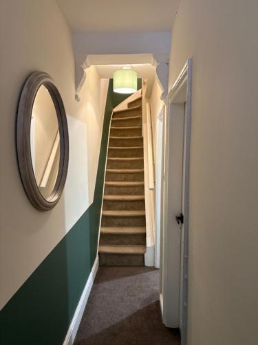 a stairway with a mirror and a staircase with a hallway at Mayfield House in Hull