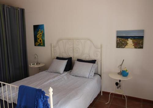 a bedroom with a white bed with a white headboard at Monte Novo da Sobreira, rust en ruimte in zuid Alentejo in Ourique