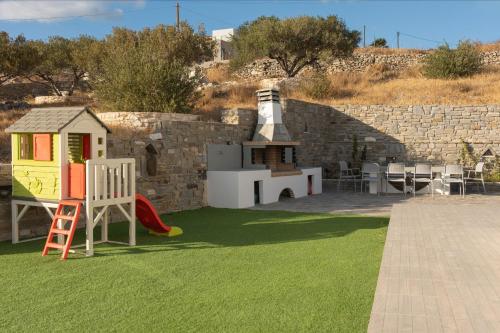 a backyard with a play yard with green grass at Villa Jessy 150m² with Full Privacy in Parikia
