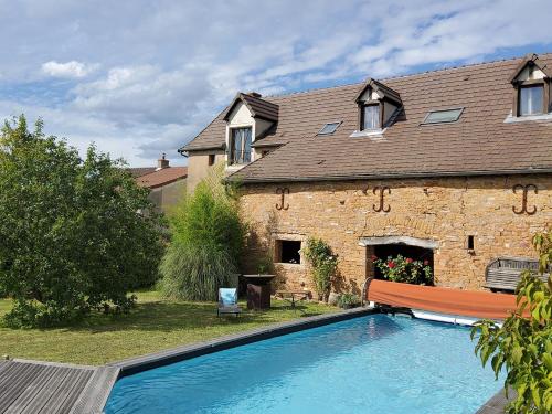 una casa con piscina delante de una casa en La Parenthèse à Etrigny, en Étrigny