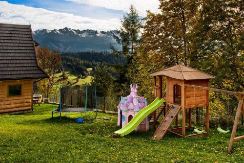 a playground with a slide and a play structure at Domki GliczarowSKI z Jacuzzi & Sauna in Zakopane
