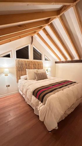 a bedroom with a large bed in a attic at Hostal RustiKo Experiencias in Diaguita
