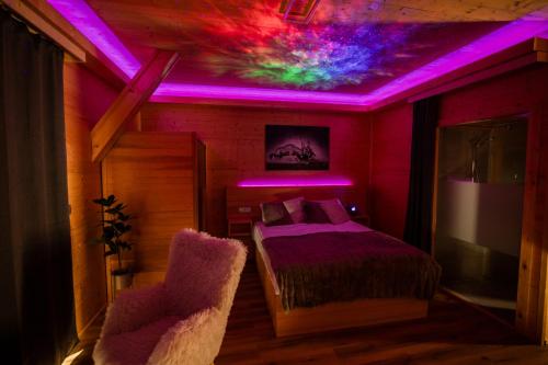a bedroom with a bed and purple lights on the ceiling at Studio Wild Park Panorama with Hot tub and Sauna in Tolsti Vrh pri Ravnah naKoroškem