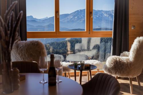a room with a table and chairs and a large window at Studio Wild Park Panorama with Hot tub and Sauna in Tolsti Vrh pri Ravnah naKoroškem
