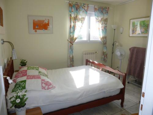 une chambre avec un lit avec des draps blancs et une fenêtre dans l'établissement Villa spacieuse 8 personnes avec piscine proche des plages, à Vias