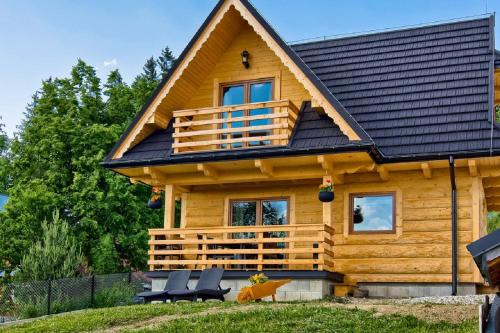 a log cabin with a black roof at Domki GliczarowSKI z Jacuzzi & Sauna in Zakopane