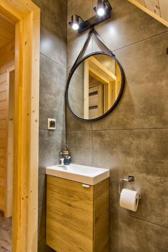 a bathroom with a sink and a mirror at Domki GliczarowSKI z Jacuzzi & Sauna in Zakopane