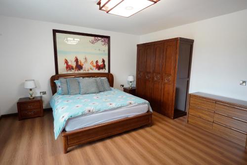 a bedroom with a bed with a painting on the wall at Tullynore Villa in Hillsborough