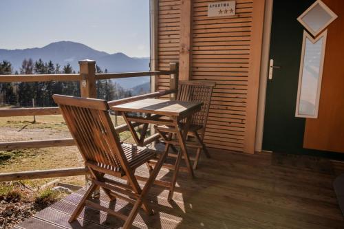 a wooden table and two chairs on a porch at Studio Wild Park Panorama with Hot tub and Sauna in Tolsti Vrh pri Ravnah naKoroškem