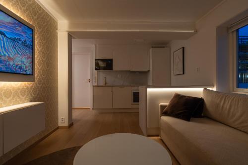 a living room with a couch and a kitchen at Luksuriøs leilighet midt i Bodø in Bodø