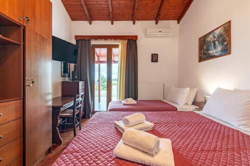 a bedroom with two beds and a desk and a desk at Kalos Vintage Villa in Kalós