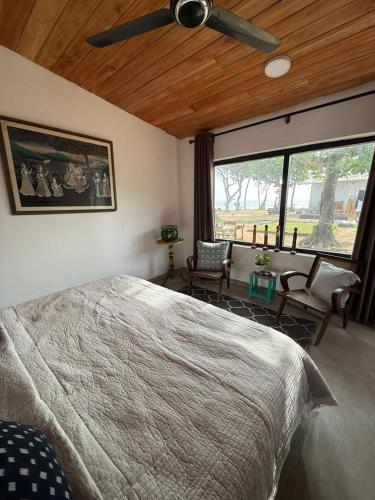 a bedroom with a large bed and a large window at Villa ArthurCC in Hikkaduwa