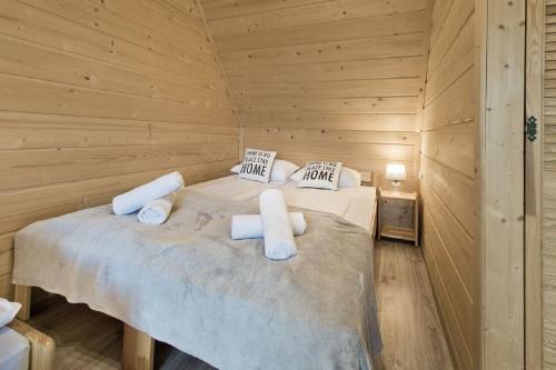 a bedroom with a bed in a wooden cabin at Domki GliczarowSKI z Jacuzzi & Sauna in Zakopane