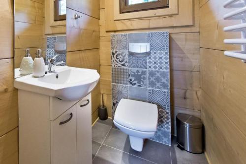 a small bathroom with a toilet and a sink at Domki GliczarowSKI z Jacuzzi & Sauna in Zakopane