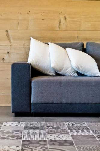 two pillows sitting on a blue couch in a room at Domki GliczarowSKI z Jacuzzi & Sauna in Zakopane