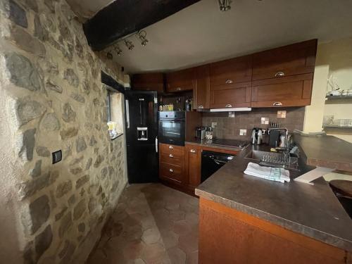 Le BrocにあるAppartement 110m2 Jacuzzi & Vueの石壁のキッチン(カウンタートップ付)