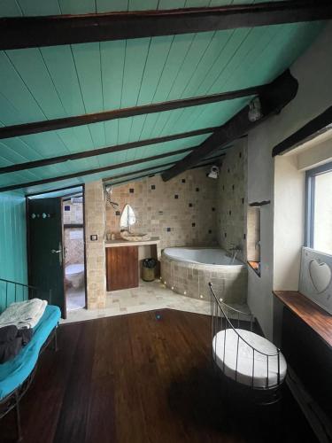 une grande chambre avec une baignoire et une chambre dans l'établissement Appartement 110m2 Jacuzzi & Vue, à Le Broc